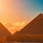 View the stunning piraminds against a vibrant sunset, highlighting their ancient grandeur.